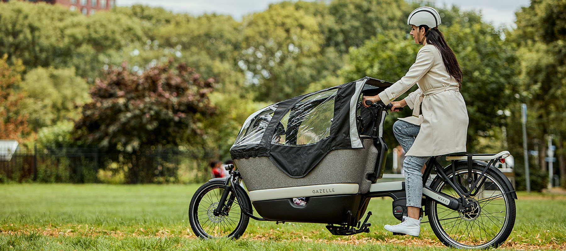 Kvinde på en grå elektrisk ladcykel med børn