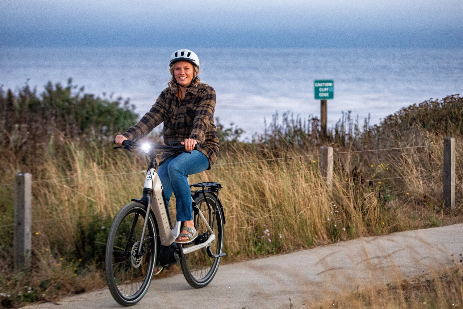 Woman riding Dutch bike by the sea