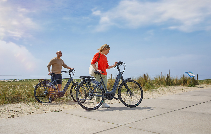 E-Bike-Urlaub. Mann und Frau mit grauem Elektrofahrrad Gazelle