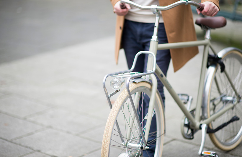 Man loopt met groene Union fiets door Leiden
