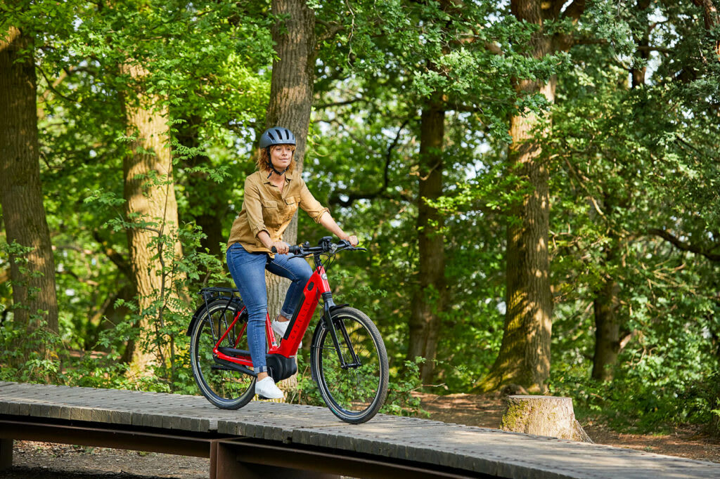 Frau mit Helm auf rotem Fahrrad