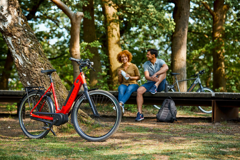 Mann und Frau mit rotem Fahrrad